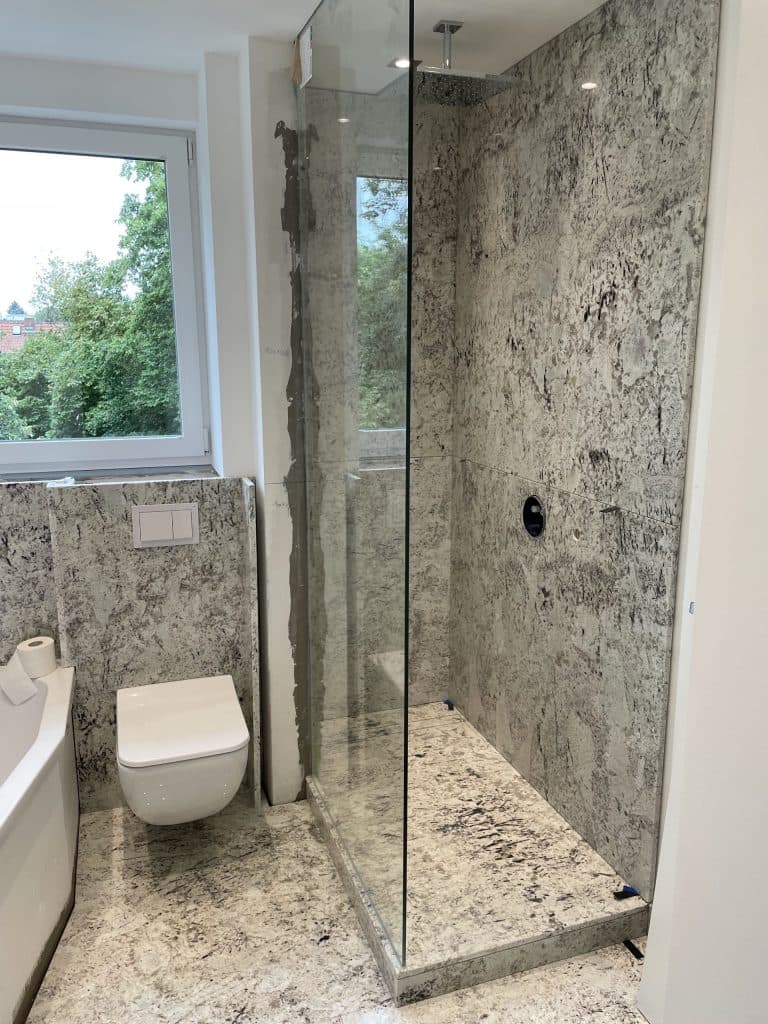 Dusche mit Glaswand neben dem Hänge-WC