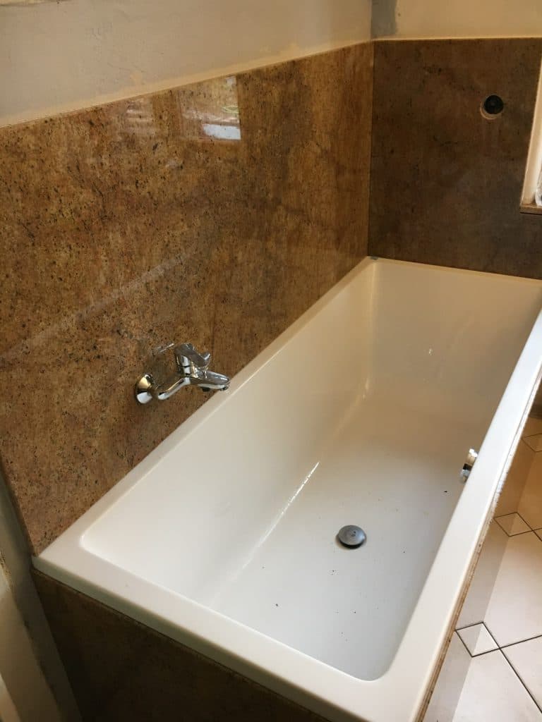 Badewanne mit Natursteinwand