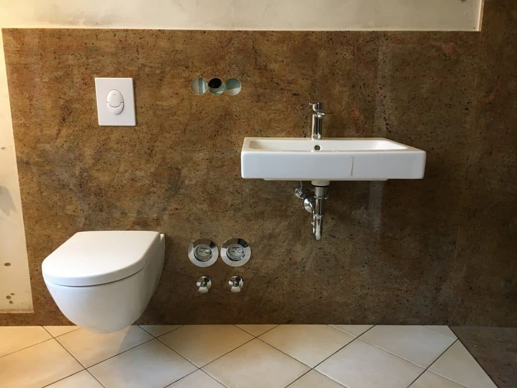 Hänge-WC und Waschtisch vor Natursteinwand