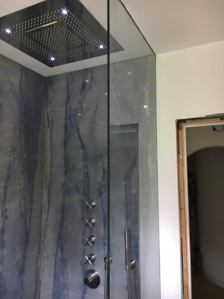 Regendusche mit Licht über blauem Naturstein
